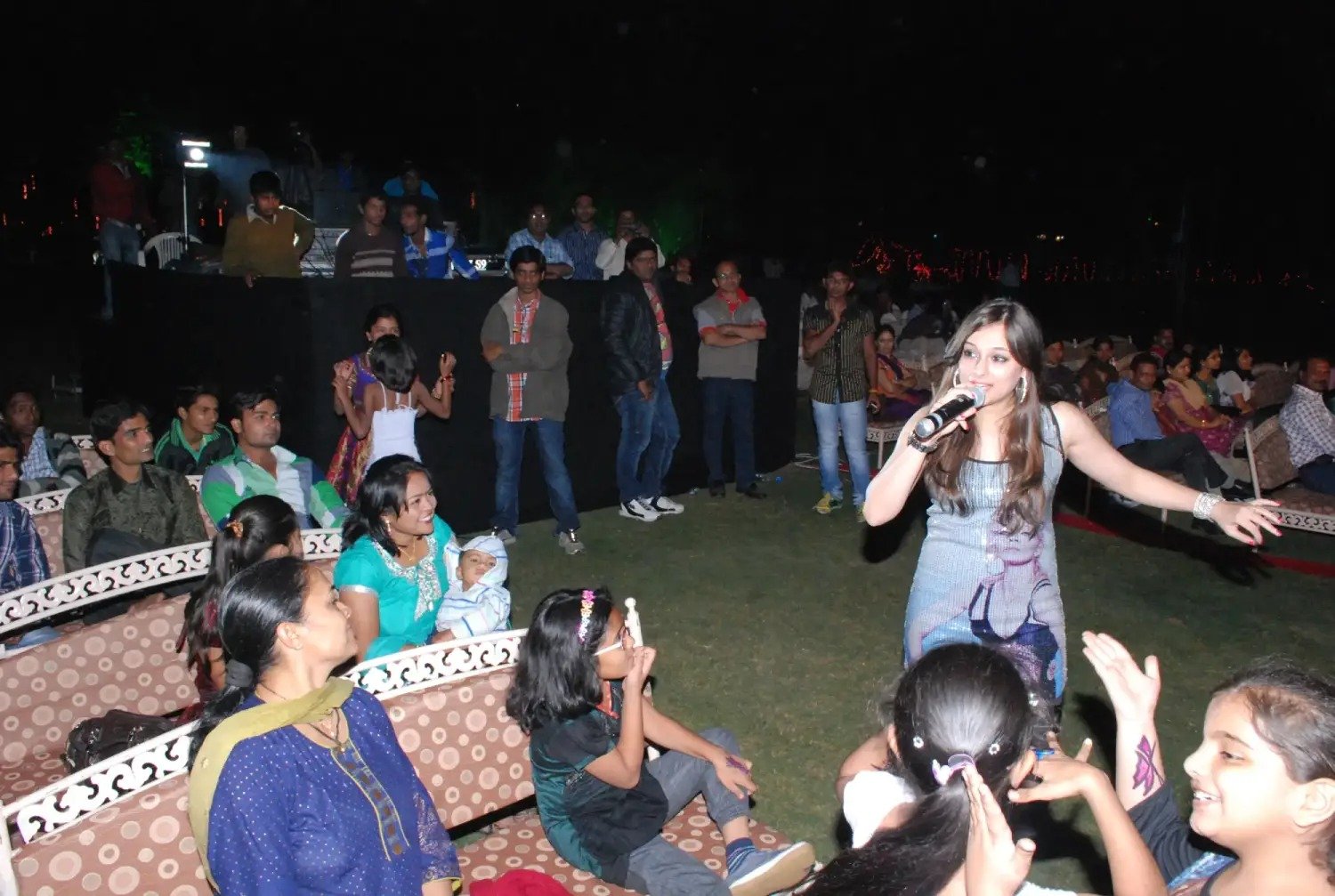 Man and woman speaking on stage at night with blue lighting